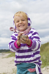 Dänemark, Ringkoebing, kleines Mädchen bildet Sandball - JFEF000201