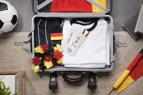 Football shirt , tickets and fan articles packed in suit case, studio shot stock photo