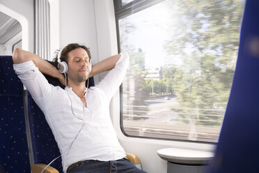 Mann mit Kopfhörern in einem Zug - KFF000258