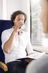 Mann trinkt Kaffee in einem Zug - KFF000255