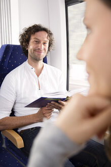 Mann liest Buch in einem Zug - KFF000280
