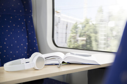 Buch, Smartphone und Kopfhörer in einem Zug - KFF000252