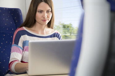 Woman using laptop in a train - KFF000250