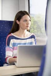 Woman using laptop in a train - KFF000249