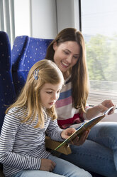 Mutter und Tochter lesen ein Buch in einem Zug - KFF000245