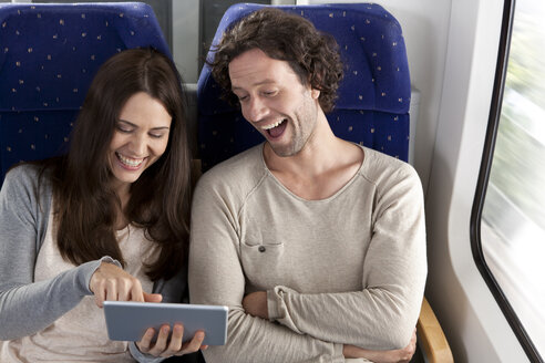 Ehepaar benutzt digitales Tablet in einem Zug - KFF000236