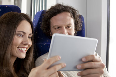Ehepaar benutzt digitales Tablet in einem Zug - KFF000234