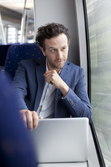 Geschäftsmann mit Laptop in einem Zug - KFF000222