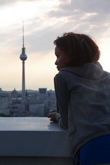 Deutschland, Berlin, Junge Frau auf Dachterrasse, Blick auf Aussicht - FKF000273
