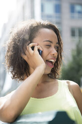 Deutschland, Berlin, Junge Frauen in der Stadt, die ein Mobiltelefon benutzen - FKF000239