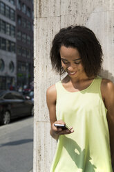 Deutschland, Berlin, Junge Frauen in der Stadt, die ein Mobiltelefon benutzen - FKF000296