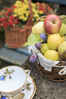 Deutschland, Bayern, Körbe mit frischem Obst und Blumen und eine Teetasse - VTF000034