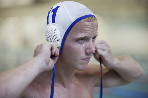 Wasserballspieler vor dem Schwimmbad beim Aufsetzen der Kappe - SEF000064