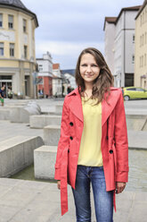 Germany, Thurinigia, Sonneberg, Brunette teenage girl in pink coat outdoors - VTF000037