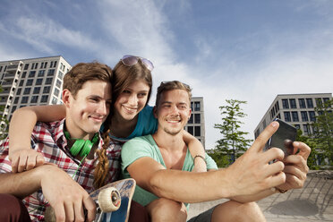 Deutschland, Bayern, München, Drei Freunde mit Smartphone beim Selbstporträt - RBF001376