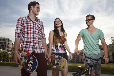 Germany, Bavaria, Munich, Friends walking with skateboard and BMX bicycle - RBF001364