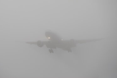 Germany, Hesse, Frankfurt, Landing airplane in fog - AM000953
