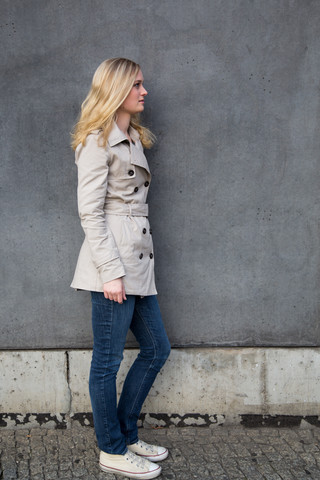 Blonde Frau vor einer Mauer, lizenzfreies Stockfoto