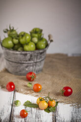 Different red and green tomatoes in bucket, studio shot - SBDF000231
