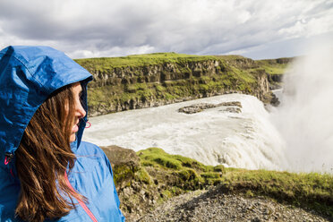 Iceland, female tourist at the famous Gullfoss Waterfall - MBEF000744