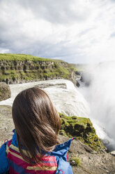Iceland, female tourist at the famous Gullfoss Waterfall - MBEF000743