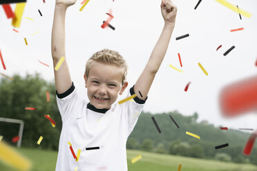 Boy in soccer jersey cheering on soccer pitch - PDF000460