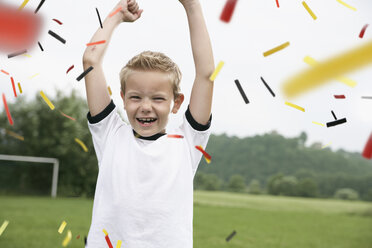 Boy in soccer jersey cheering on soccer pitch - PDF000461