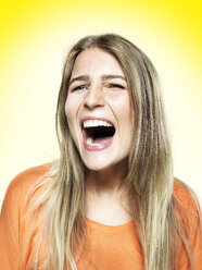 Portrait of screaming young woman, studio shot - STKF000358