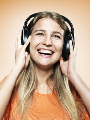 Portrait of young woman with headphones, studio shot - STKF000359