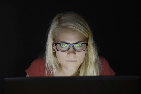 Junge Frau benutzt Laptop bei Nacht, lizenzfreies Stockfoto
