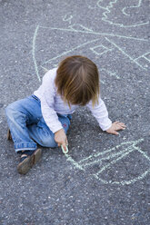 Germany, Baden-Wuerttemberg, little girl drawing with crayon on asphalt - LVF000215