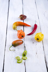 Colored chilis on wooden table - ODF000550
