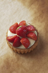 Kuchen mit Vanillepudding und Erdbeeren auf Backpapier, Studioaufnahme - CSF020129