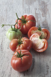 Whole and sliced Silesian raspberry tomatoes (Solanum lycopersicum), studio shot - CSF020141