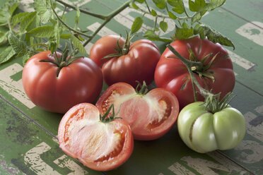 Whole and sliced Silesian raspberry tomatoes (Solanum lycopersicum), studio shot - CSF020142