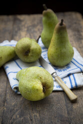 Five pears, placemat and a knife on wooden table, studio shot - LVF000225