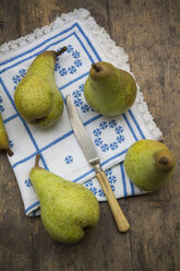 Four pears, placemat and a knife on wooden table, studio shot - LVF000229