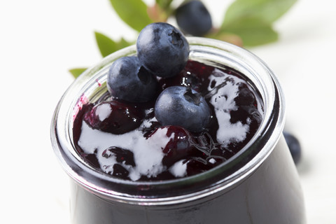 Glas Blaubeermarmelade und einige Beeren, Studioaufnahme, lizenzfreies Stockfoto