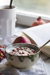 Healthy breakfast with pomegranate in yogurt, coffee and opened book - SBDF000247