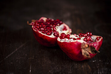 Opened pomegranate on dark surface, studio shot - SBDF000257