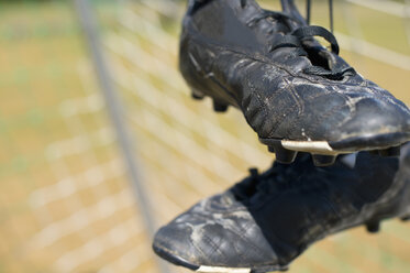 Deutschland, Bayern, München, Fußballschuhe hängen im Fußballnetz - ASF005202