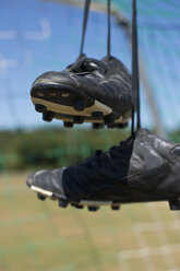 Deutschland, Bayern, München, Fußballschuhe hängen im Fußballnetz - ASF005203