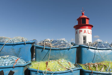 Frankreich, Bretagne, Landeda, Leuchtturm und Kisten mit Fischernetzen im Hafen - LA000208