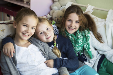 Three happy girls on bed - GDF000224