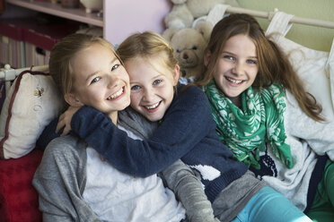 Three happy girls on bed - GDF000225