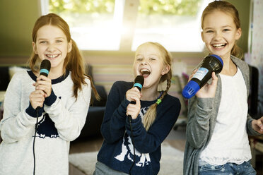 Three girls singing with microphone - GDF000226