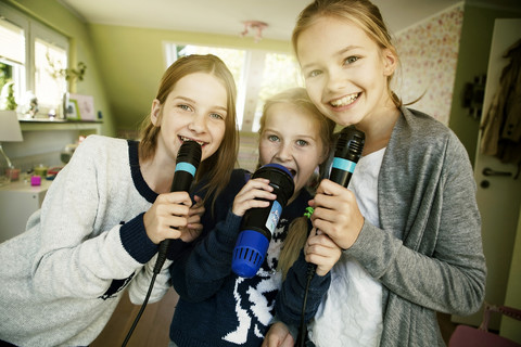 Drei Mädchen singen mit Mikrofon, lizenzfreies Stockfoto