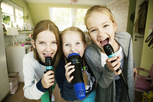 Three girls singing with microphone - GDF000229