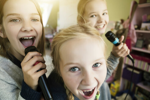 Three girls singing with microphone - GDF000230