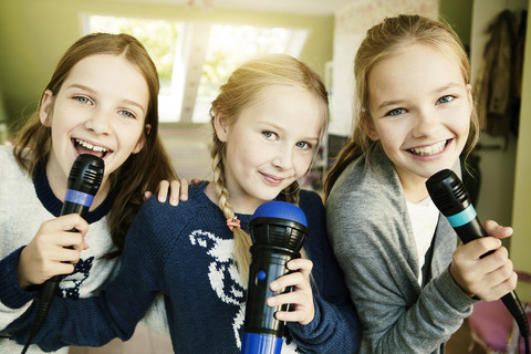 Three girls singing with microphone stock photo